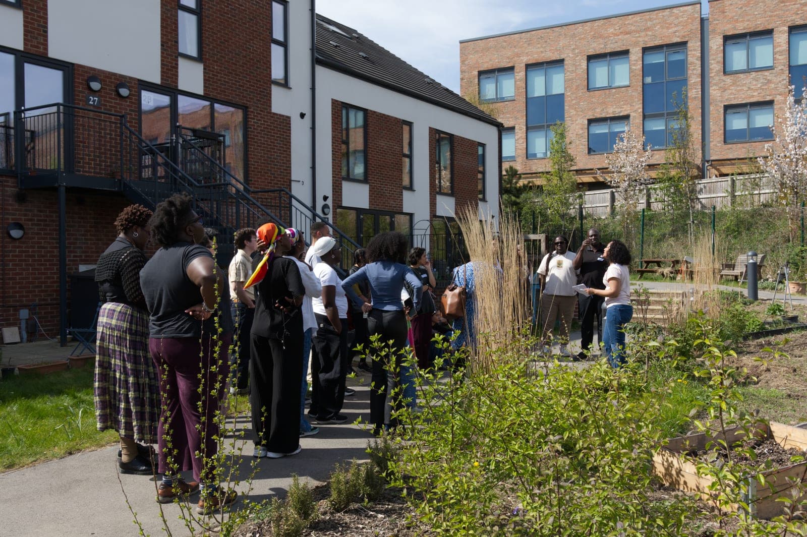 A group on a guided tour of Chapeltown Cohousing led by Cynthia Brathwaite